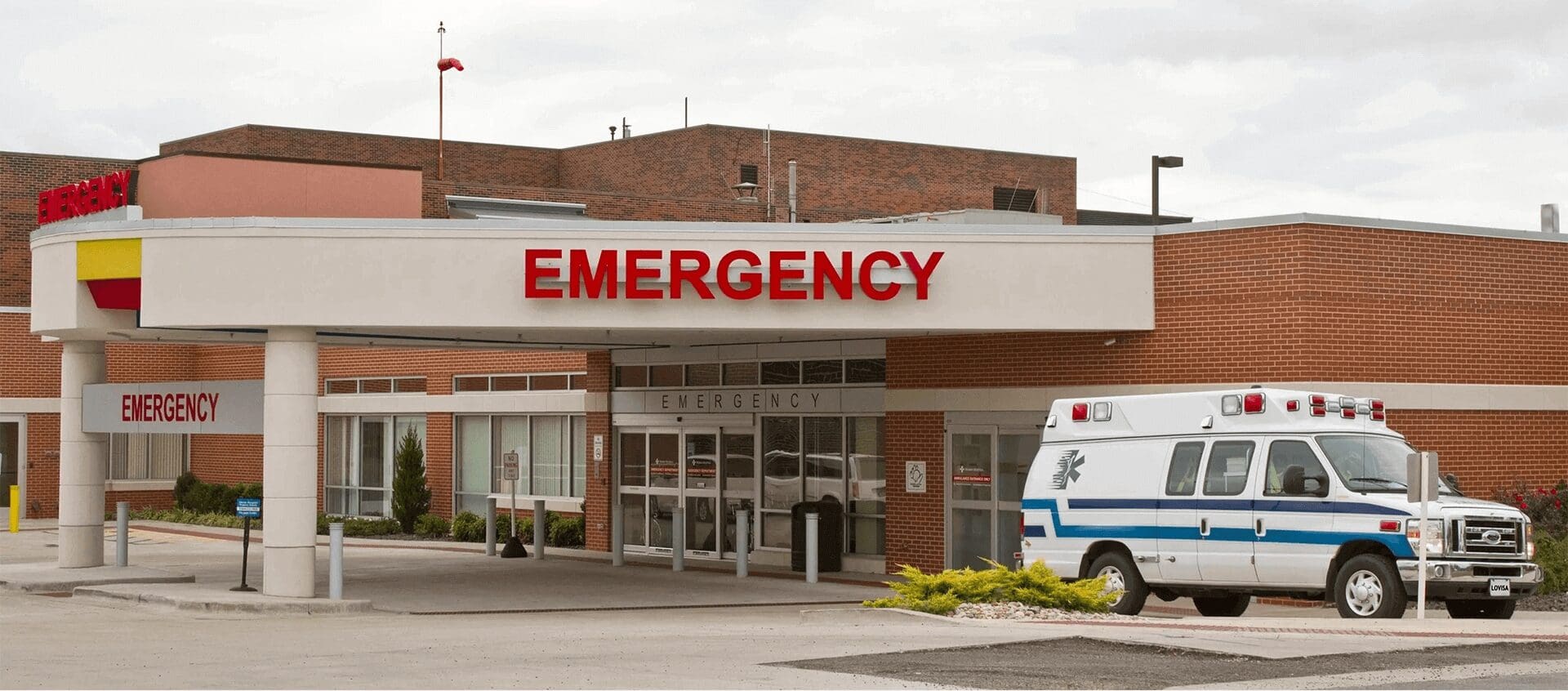 A hospital emergency room with an ambulance parked outside.